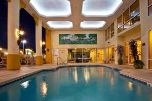 una piscina en el vestíbulo de un hotel con un edificio en Holiday Inn Express Hotel & Suites Cocoa Beach, an IHG Hotel, en Cocoa Beach