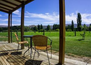 een tafel en stoelen op een veranda met uitzicht op een veld bij Dunstan Road B&B in Alexandra