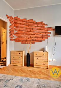 a living room with a brick wall and a dresser at Apartamenty Wójcik Loft in Gdynia