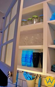 a kitchen pantry with blue glasses in it at Apartamenty Wójcik Loft in Gdynia