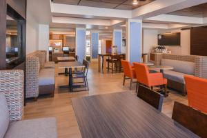 een eetkamer met tafels en stoelen en een eettafel bij Holiday Inn Express Hotel & Suites Urbana-Champaign-U of I Area, an IHG Hotel in Champaign