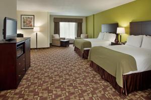 a hotel room with two beds and a flat screen tv at Holiday Inn Express Hotel & Suites Kansas City Sports Complex, an IHG Hotel in Kansas City