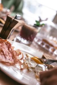 a plate of food on a table with food on it at Mosella Suite Hotel in Sottomarina