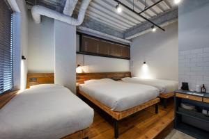 2 Betten in einem Zimmer mit 2 Fenstern in der Unterkunft mizuka Imaizumi 1 - unmanned hotel - in Fukuoka