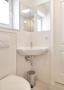 a white bathroom with a sink and a toilet at Haus Südwester Strandschnecke in Timmendorf