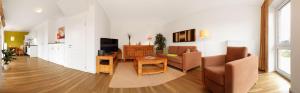 a living room with a couch and a table and chairs at Haus Südwester Strandschnecke in Timmendorf