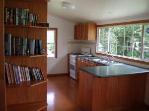 a kitchen with a book shelf filled with books at Dayboro - Blue Ridge Lavender Cottage in Dayboro