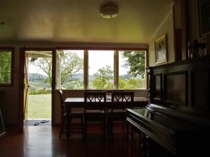 une salle à manger avec une table et un piano dans l'établissement Dayboro - Blue Ridge Lavender Cottage, à Dayboro 10 autres photos