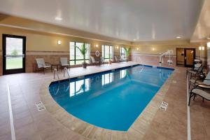 een groot zwembad in een hotel met stoelen en tafels bij Holiday Inn Express Hotel & Suites Clearfield, an IHG Hotel in Clearfield
