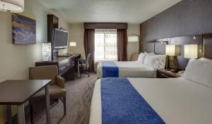 a hotel room with two beds and a desk at Holiday Inn Express Hotel & Suites Meadowlands Area by IHG in Carlstadt +34 photos