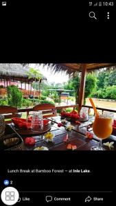 a restaurant with a table with food and a drink at Bamboo Forest River View Hostel in Ywama