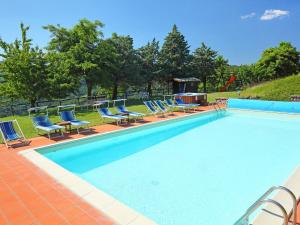 una gran piscina con sillas y parrilla en Apartment Azienda Agricola Piano Rosso-4 by Interhome, en Marradi