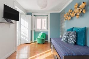 リスボンにあるAvenida da Liberdade Area, Bright and Newly Renovated 2 Bedroom Apartment, Lisbon Historical Centerの青い壁のベッドルーム(ベッド1台、テレビ付)