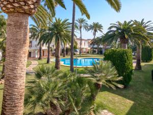 a resort with palm trees and a swimming pool at Holiday Home La Aldea by Interhome in Denia