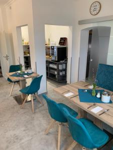 
a kitchen with a table, chairs and a refrigerator at Hotel Hanseat Stralsund in Stralsund
