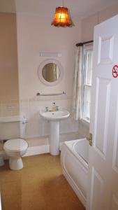 Baño blanco con lavabo y aseo en Leadon House Hotel, en Ledbury