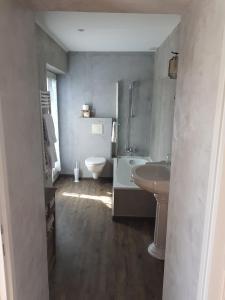 uma casa de banho com um lavatório, uma banheira e um WC. em Le Crillon em Murs