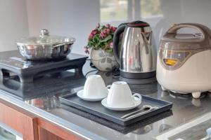 a kitchen counter with two cups on a tray at The Flamboyant #StayWork Vinhomes Imperia in Hai Phong
