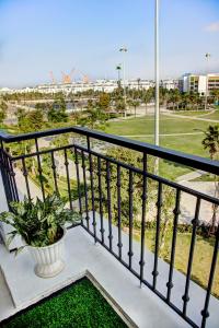 a balcony with a potted plant and a golf course at The Flamboyant #StayWork Vinhomes Imperia in Hai Phong