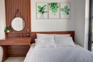 a bedroom with a bed with a mirror on the wall at The Flamboyant #StayWork Vinhomes Imperia in Hai Phong