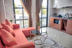 a living room with a red couch and a table at The Flamboyant #StayWork Vinhomes Imperia in Hai Phong