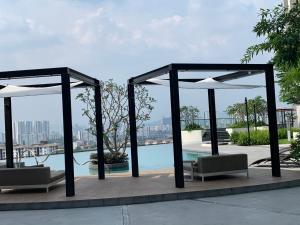 a pavilion with chairs and a pool on a building at Paul 2 bedroom apartment at 28 Boulavard in Kuala Lumpur