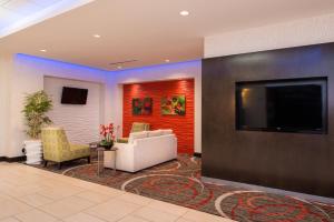 Una sala de estar con un sofá y un televisor de pantalla plana. en Holiday Inn Express & Suites Monroe by IHG, en Monroe