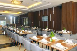 een restaurant met houten muren en tafels en stoelen bij Muong Thanh Quy Nhon Hotel in Quy Nhon