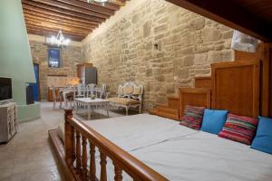 - une chambre avec un lit et un mur en pierre dans l'établissement M-Cube Malona Village House near Lindos, à Malona Village