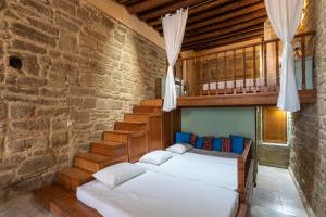- une chambre avec 2 lits et un mur en briques dans l'établissement M-Cube Malona Village House near Lindos, à Malona Village