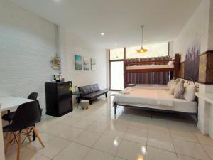 1 dormitorio con cama, sofá y mesa en Street Zone Home stay by Little Paradise, en Haad Rin
