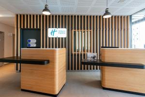 a lobby with two desks and a sign on the wall at Holiday Inn Express - Bordeaux - Lormont, an IHG Hotel in Lormont
