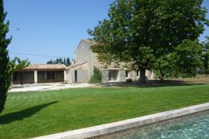 une grande cour avec une maison et un arbre dans l'établissement charmant loft à la campagne, à Cavaillon