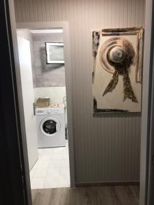 een badkamer met een wasmachine en een schilderij aan de muur bij Aster Beach House in Néa Thésis