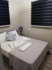 Un dormitorio con una cama con dos servilletas blancas. en Aster Beach House, en Néa Thésis
