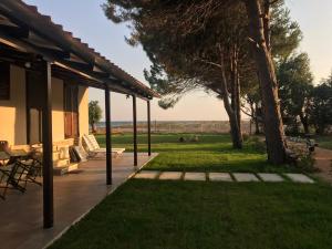 a patio with a table and chairs and a tree at Aster Beach House in Néa Thésis