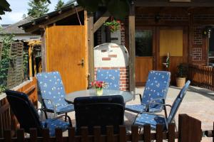 d'une terrasse avec 4 chaises et une table fleurie. dans l'établissement Gepetto Ferienhaus Wissenbach, à Hademstorf