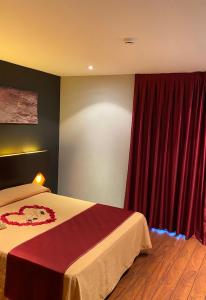 sypialnia z łóżkiem i czerwoną zasłoną w obiekcie Hostal Royal Almorox w mieście Almorox