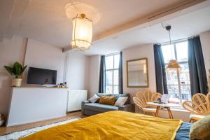 a bedroom with a bed and a couch and a tv at Bambu Sleep Boutique in Haarlem