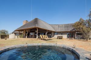 a house with a large swimming pool in front of it at Zebula 116 in Mabula