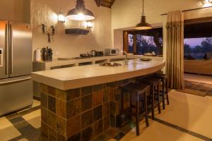 a kitchen with a large island with bar stools at Zebula 116 in Mabula