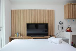 a bedroom with a bed and a television on a table at Best Deal The Springlake Summarecon Studio Apartment By Travelio in Bekasi