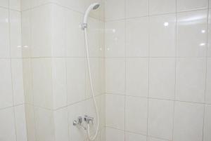 a shower with a shower head in a bathroom at Best Deal The Springlake Summarecon Studio Apartment By Travelio in Bekasi +8 photos