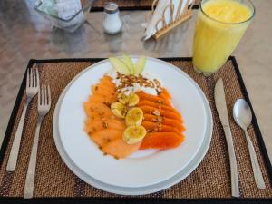 a plate of food with fruit and a glass of orange juice at Suites Arboleda 215 in Mexico City