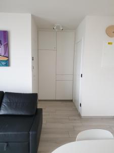 a living room with a black couch and a closet at Appartement, residentie Syci in Koksijde