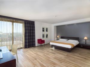 una camera con letto e scrivania e una camera di Grand Hotel Tiziano E Dei Congressi a Lecce