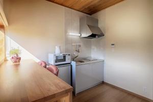 a small kitchen with a table and a refrigerator at Kitaguchi Tougakukan in Fujiyoshida