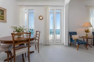 a dining room with a table and chairs and the ocean at Andriani Apartment in Zakynthos