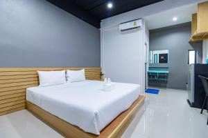 Ban Yep Chaeng的住宿－CS Klongtoey Grand Resort，卧室配有白色的床和电视。