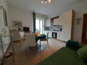ein Wohnzimmer mit einem Tisch und einer Küche in der Unterkunft Saglia Apartments in Malcesine